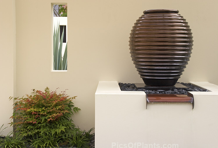 A bronze-coloured, urn-like water feature.